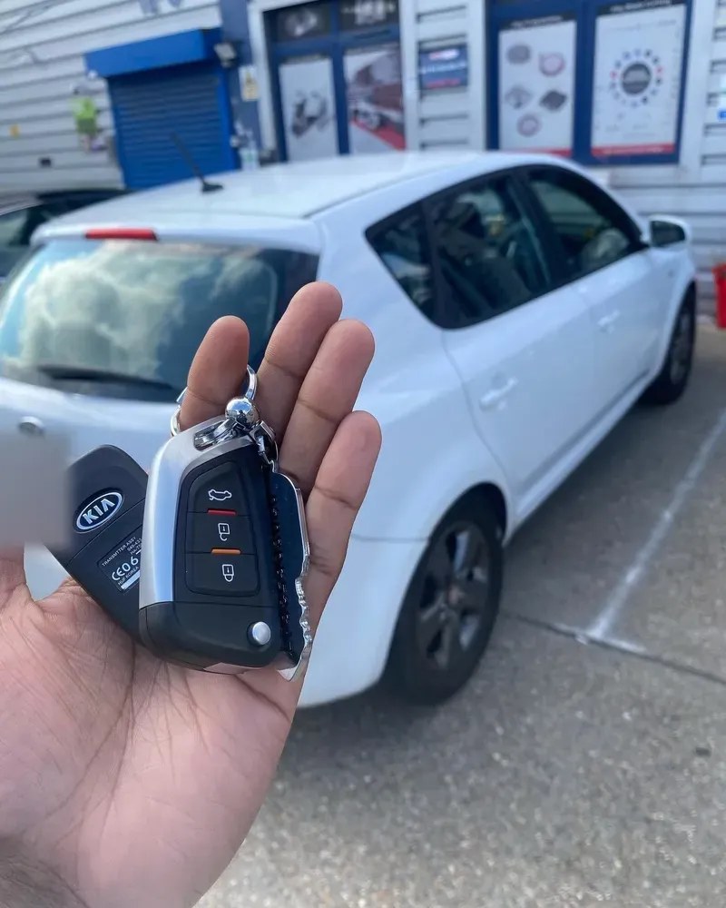 Replacement Kia smart key held in front of the car it was cut and coded for