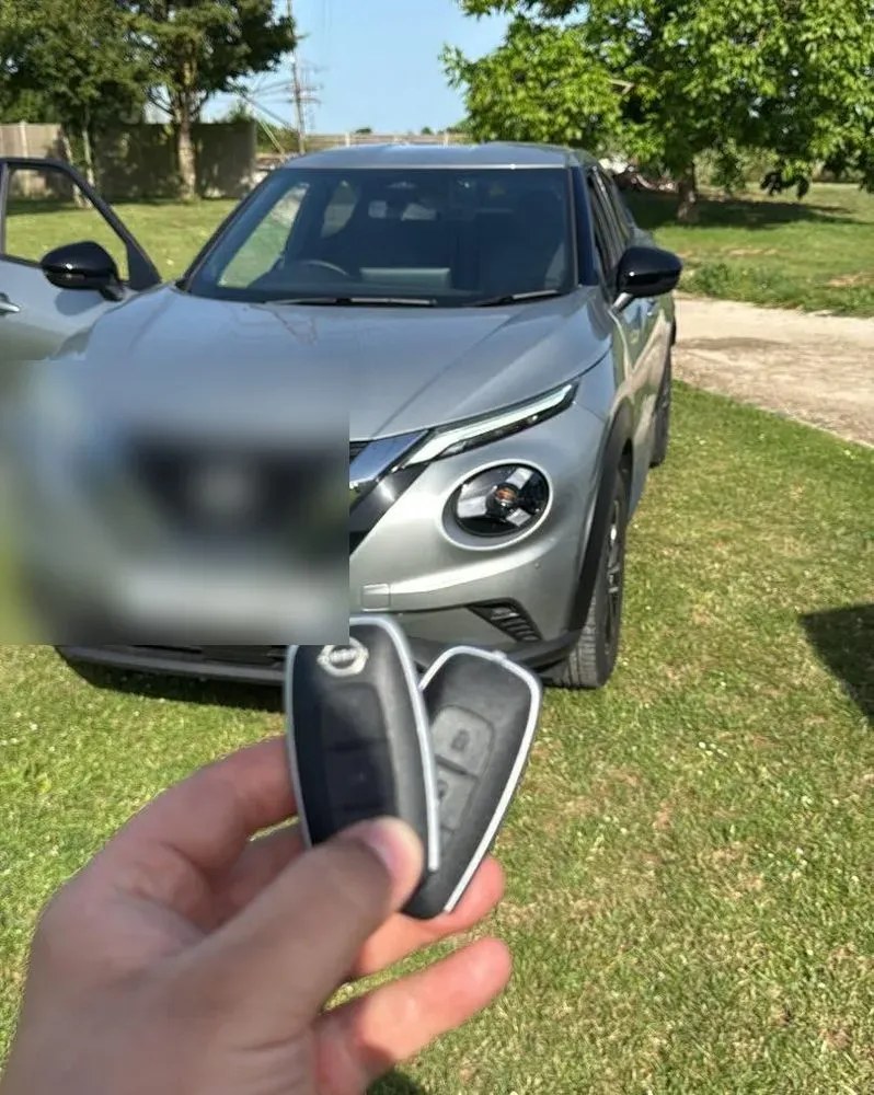 New car key handed to a customer beside their car
